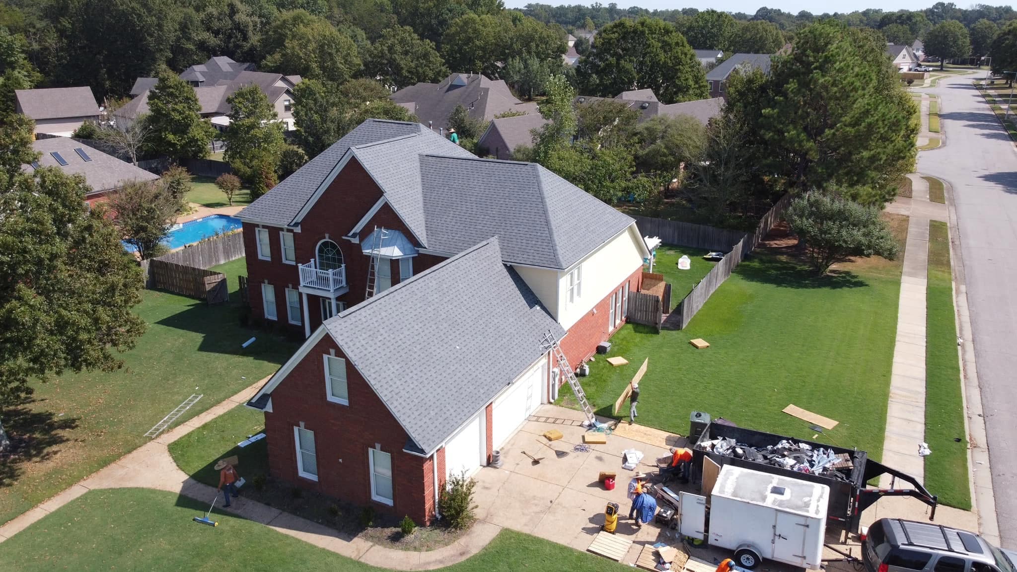 Finished architectural shingle roof by Precision Roofing and Exteriors on a brick home in the Memphis area, aerial drone view