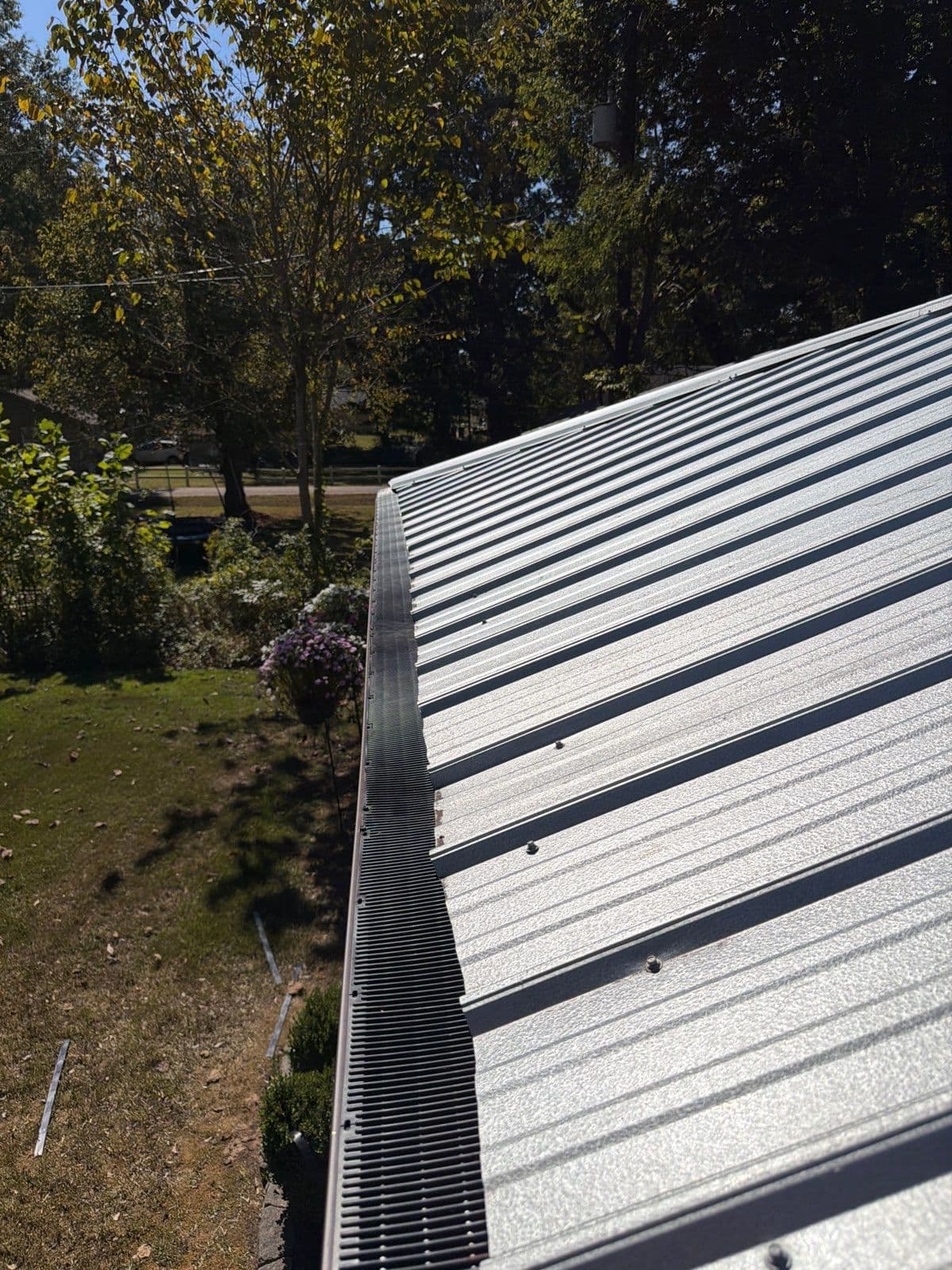 Black Raindrop gutter guard installed along the eave of a metal roof
