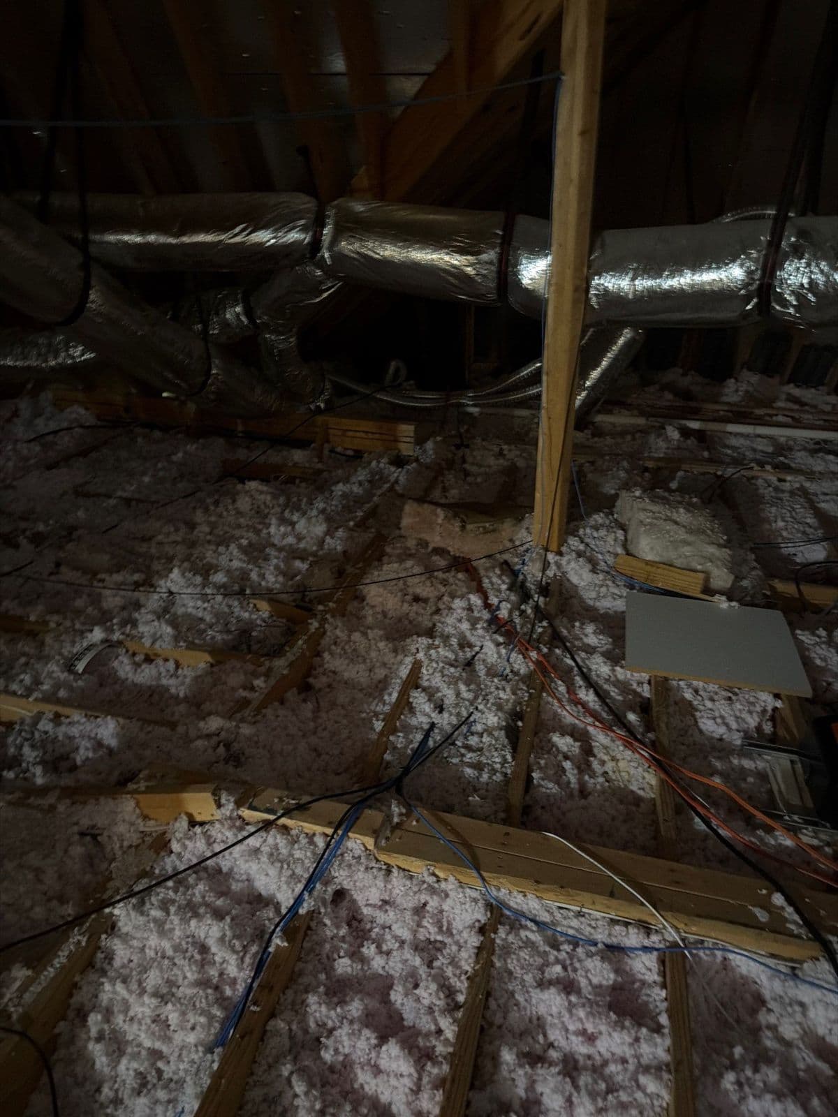 Thin, patchy old attic insulation with the ceiling joists showing through
