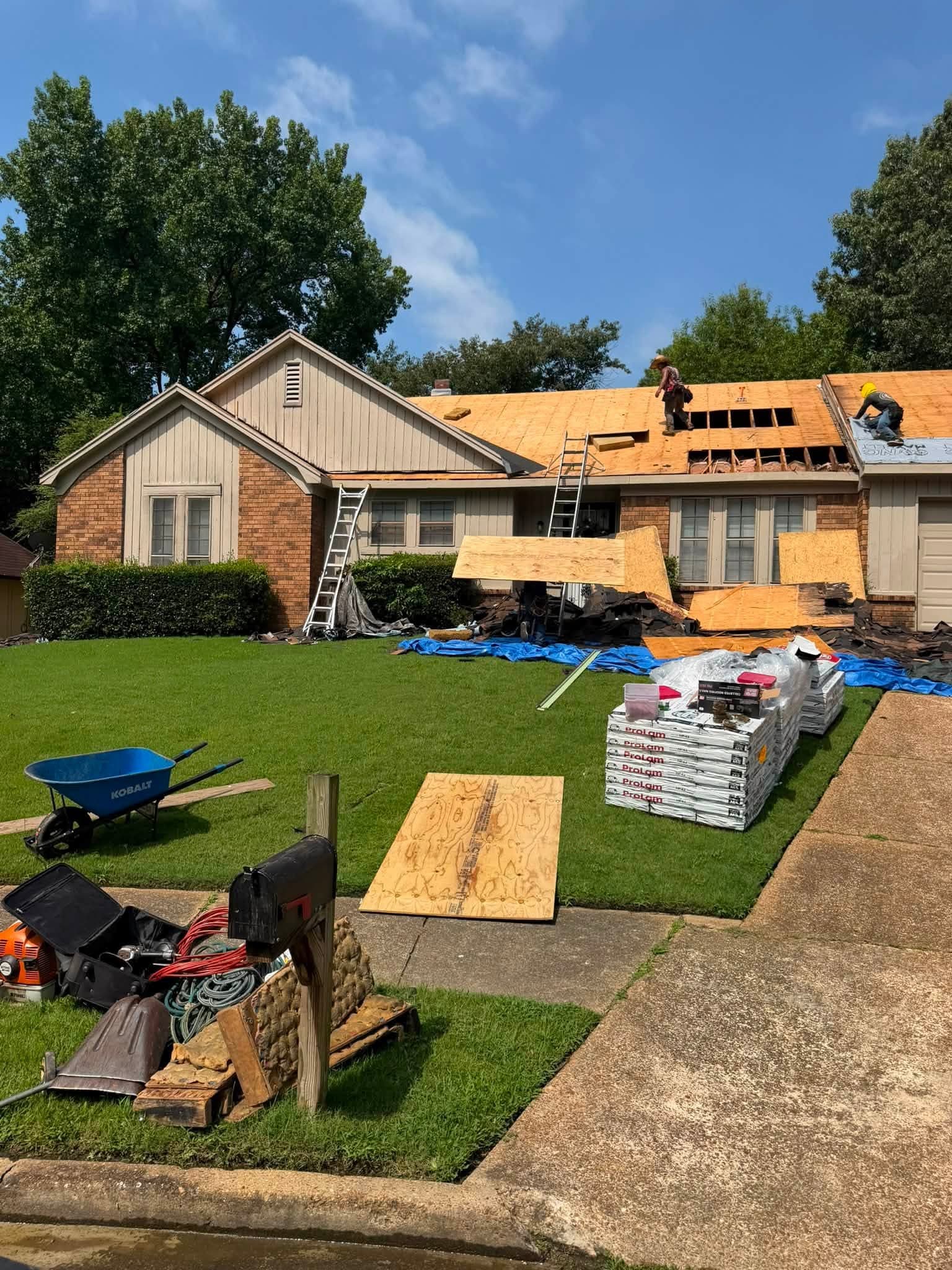 Crew replacing damaged roof decking sections on a ranch home