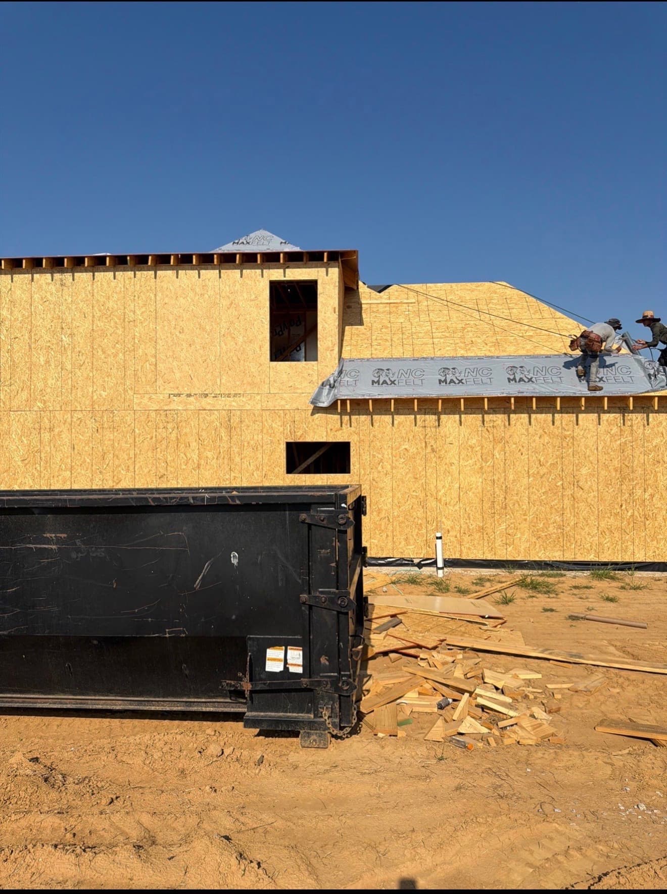 Precision Roofing and Exteriors crew rolling synthetic underlayment on a Memphis-area roof