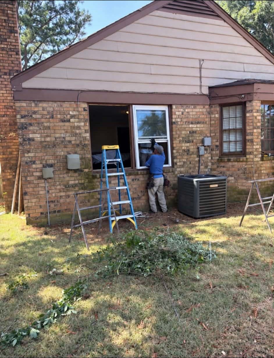 Installer fitting a new double-pane window into the original brick opening of a Memphis-area home